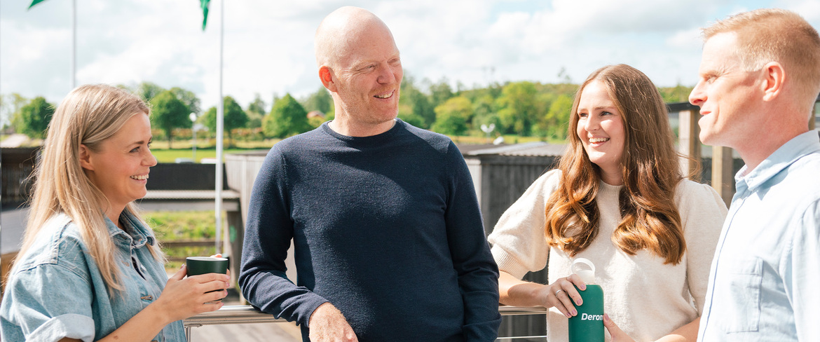 Fyra kollegor från Derome för ett samtal mellan varandra i en utomhusmiljö. 
